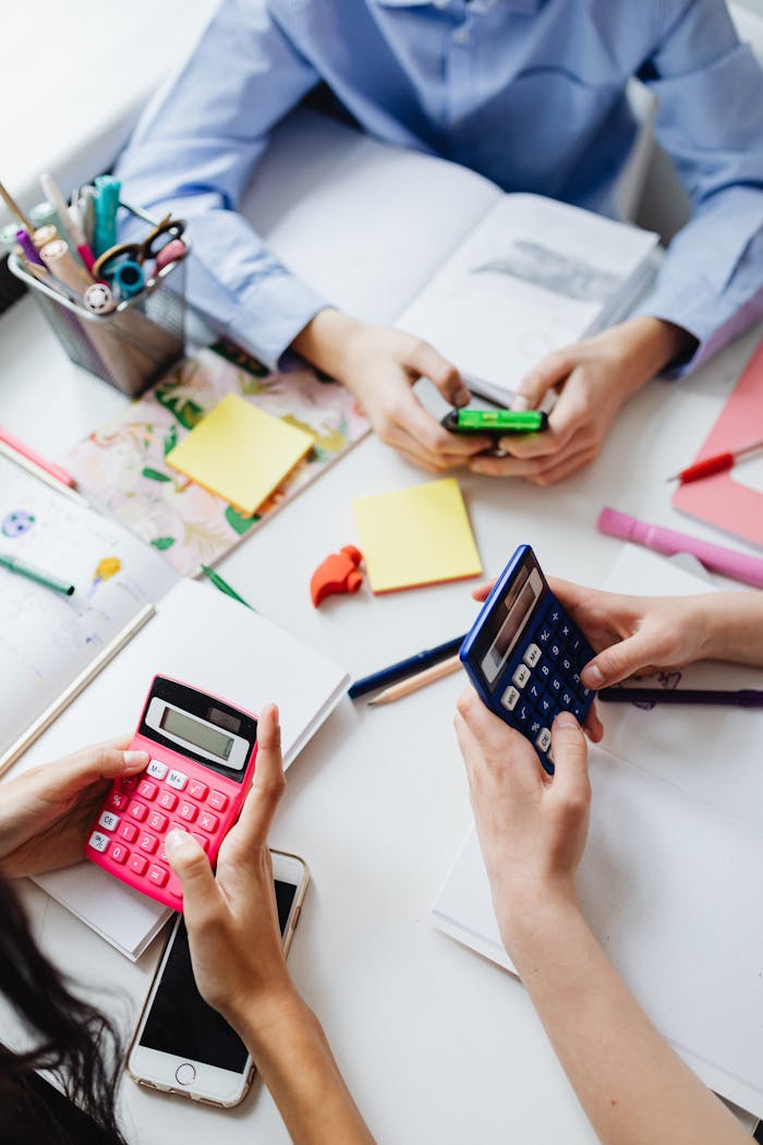 Group of children using calculators for math homework in a classroom.